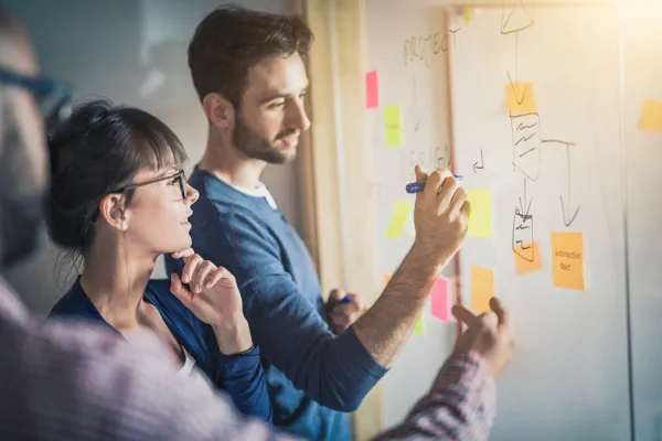 Symbolbild für datenbasierte Content-Strategie mit Team bei der visuellen Planung und Analyse am Whiteboard